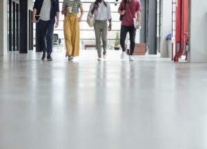 college students walking through a corridor with focus on the floor