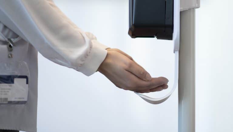 Medical Professional using a touchless sanitizer dispenser