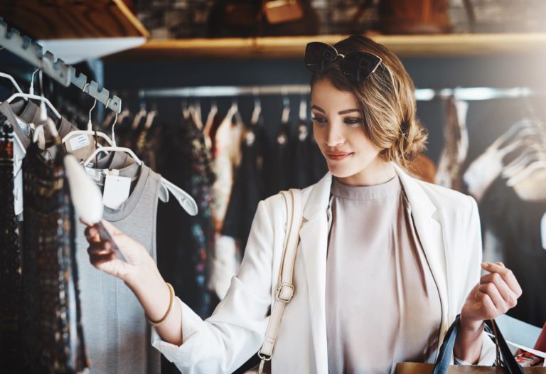 Woman looking at dresses in boutique clothing store