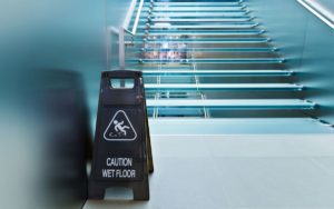 wet floor caution sign on glass staircase